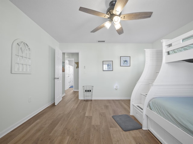 bedroom with baseboards, ceiling fan, visible vents, and light wood finished floors