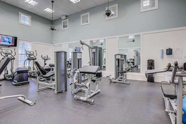 gym with a drop ceiling and a towering ceiling