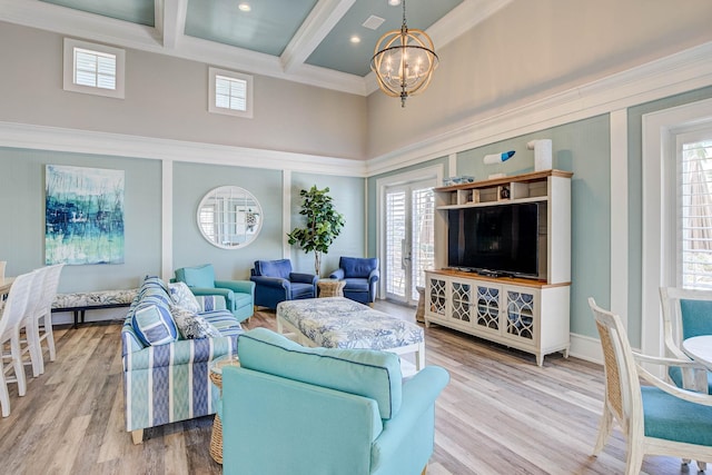 living room with wood-type flooring, a chandelier, beamed ceiling, and a wealth of natural light