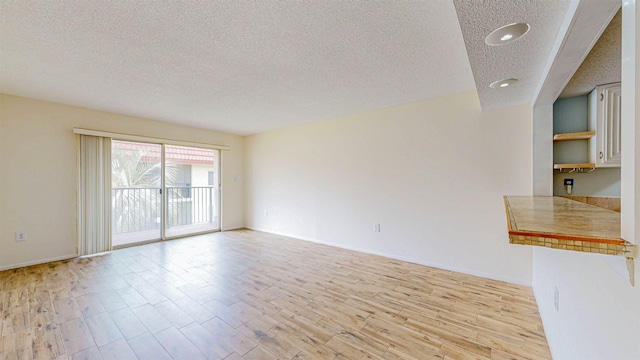 7175 A1A S # F238 # F238, Saint Augustine, FL 32080 - unfurnished living room featuring a textured ceiling, light wood-style floors, recessed lighting, and baseboards