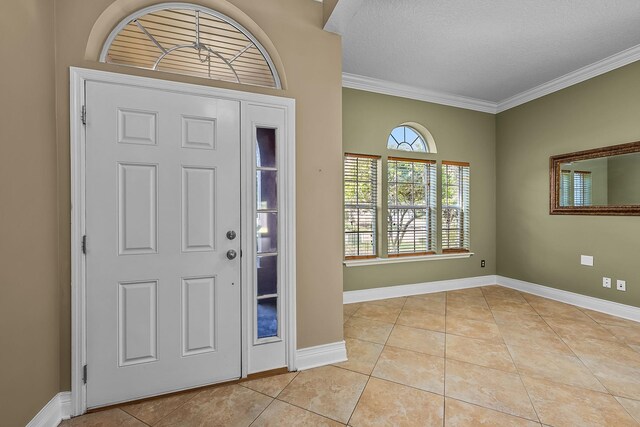 tiled entryway with ornamental molding and a textured ceiling