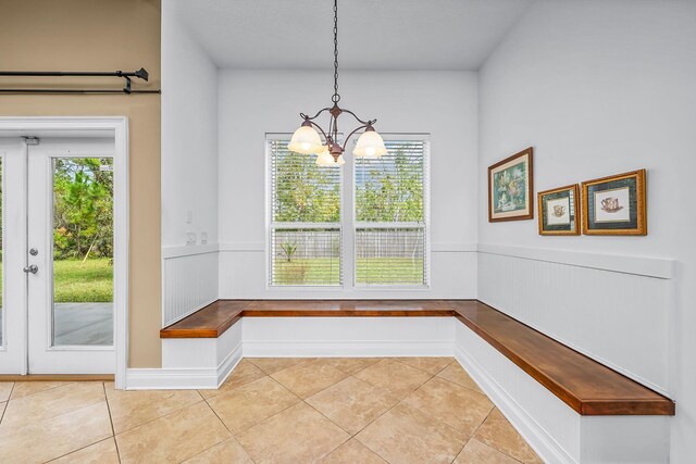 mudroom featuring a notable chandelier and light tile patterned floors