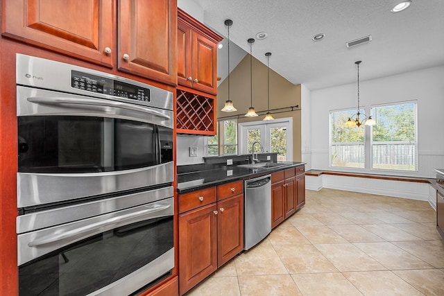 kitchen featuring stainless steel appliances, sink, light tile patterned floors, a chandelier, and hanging light fixtures