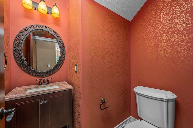 bathroom featuring vanity, a textured ceiling, toilet, and vaulted ceiling