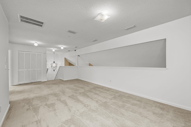 carpeted spare room with a textured ceiling