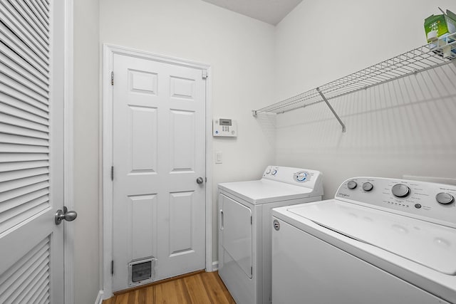 laundry area with light hardwood / wood-style floors and washing machine and clothes dryer