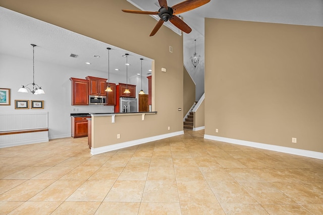 kitchen with a breakfast bar area, high vaulted ceiling, pendant lighting, and appliances with stainless steel finishes