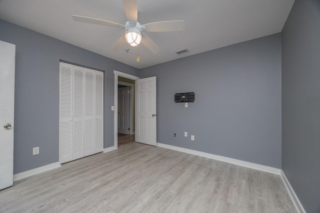 unfurnished bedroom featuring ceiling fan, a closet, and light hardwood / wood-style floors