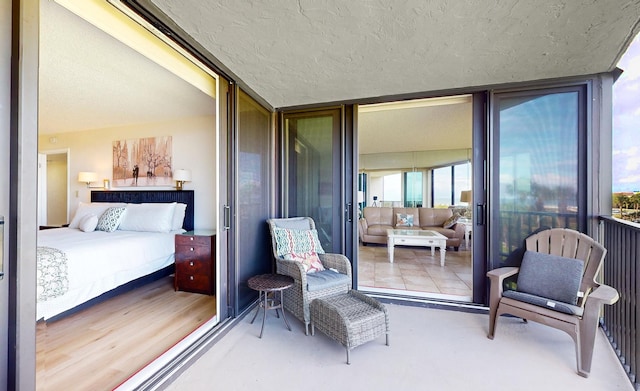 exterior space featuring hardwood / wood-style flooring, expansive windows, and a textured ceiling