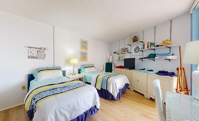 bedroom with light hardwood / wood-style floors and a textured ceiling