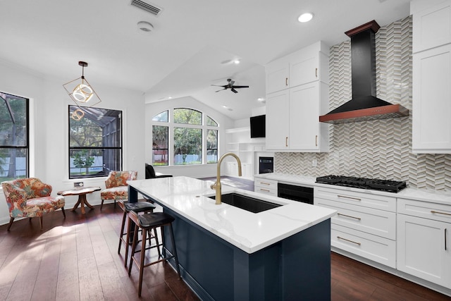 545 Sebastian Sq, Saint Augustine, FL 32095 - kitchen featuring a sink, black gas stovetop, wall chimney range hood, backsplash, and white cabinetry