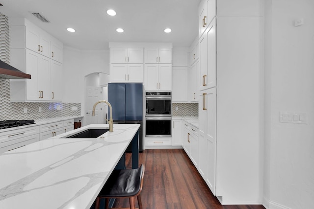 545 Sebastian Sq, Saint Augustine, FL 32095 - kitchen with double oven, a sink, refrigerator, black gas stovetop, and tasteful backsplash
