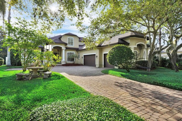 545 Sebastian Sq, Saint Augustine, FL 32095 - view of front of home with decorative driveway, an attached garage, a front lawn, and stucco siding