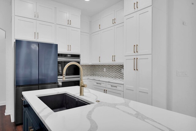 545 Sebastian Sq, Saint Augustine, FL 32095 - kitchen with fridge, white cabinets, decorative backsplash, dark wood-style floors, and recessed lighting