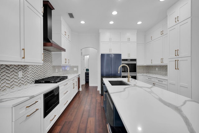 545 Sebastian Sq, Saint Augustine, FL 32095 - kitchen with black appliances, wall chimney range hood, recessed lighting, white cabinetry, and dark wood finished floors