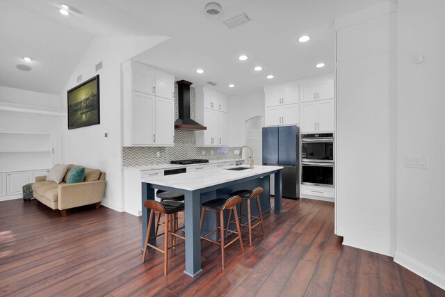 545 Sebastian Sq, Saint Augustine, FL 32095 - kitchen featuring wall chimney range hood, a sink, black appliances, a breakfast bar area, and dark wood-style floors