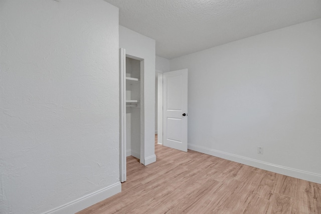 235 N Whitney St, Saint Augustine, FL 32084 - unfurnished bedroom with light wood-type flooring and a textured ceiling