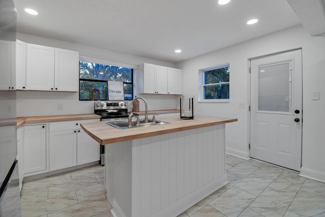 235 N Whitney St, Saint Augustine, FL 32084 - kitchen with butcher block counters, light marble finish floors, white cabinetry, and recessed lighting