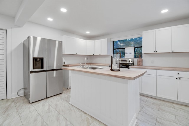 235 N Whitney St, Saint Augustine, FL 32084 - kitchen with stainless steel appliances, wood counters, light marble finish flooring, white cabinets, and recessed lighting