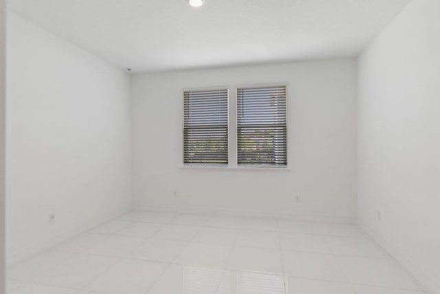 empty room featuring light tile patterned floors and baseboards