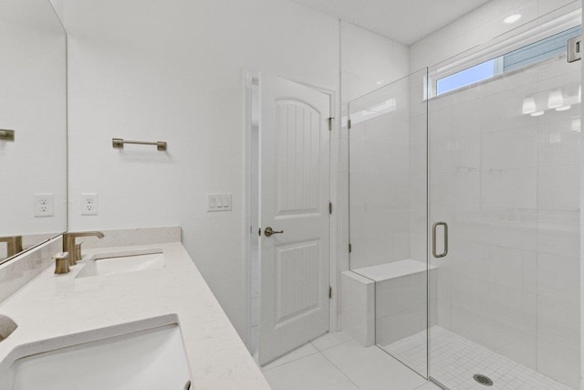 bathroom featuring double vanity, a sink, a shower stall, and tile patterned floors