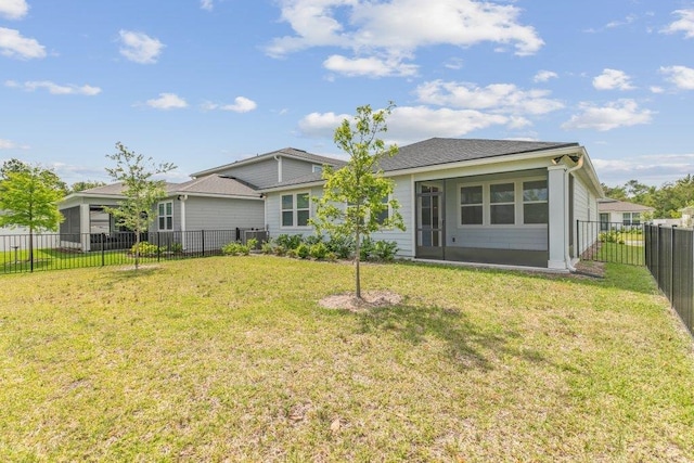 rear view of property featuring a yard and a fenced backyard