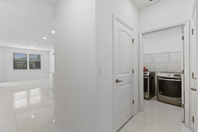 hall featuring light tile patterned flooring and separate washer and dryer