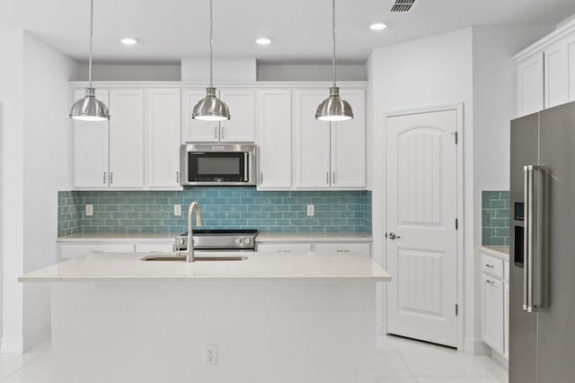 kitchen with appliances with stainless steel finishes, light countertops, white cabinets, and a sink
