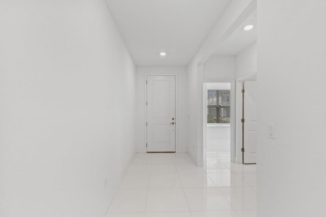hall with baseboards, recessed lighting, and light tile patterned flooring