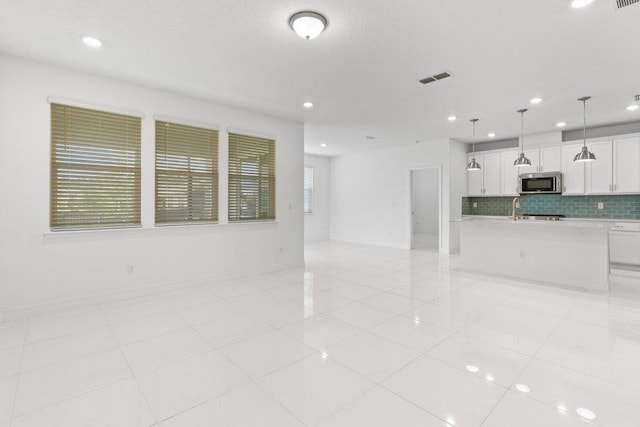 unfurnished living room with a sink, recessed lighting, visible vents, and light tile patterned floors