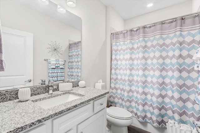 bathroom featuring vanity, curtained shower, and toilet