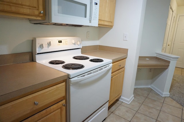 kitchen featuring light tile patterned floors and white appliances