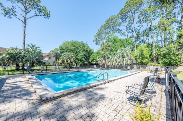 community pool featuring a patio and fence