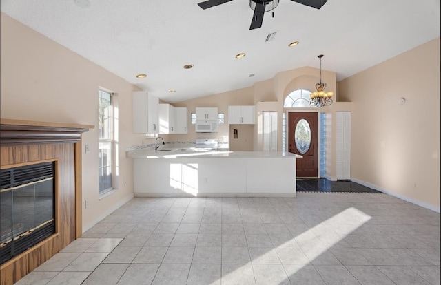 kitchen featuring white cabinetry, kitchen peninsula, vaulted ceiling, and light tile patterned floors