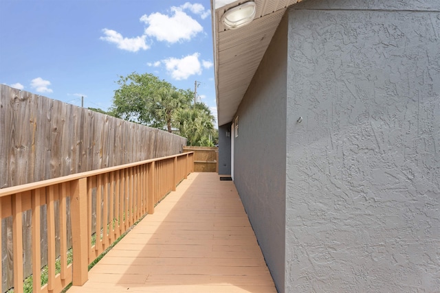 view of side of home with stucco siding and fence