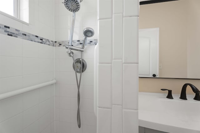 bathroom view of a sink and a tile shower