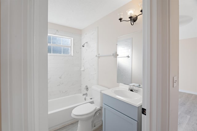 full bathroom featuring tiled shower / bath combo, hardwood / wood-style floors, toilet, a textured ceiling, and vanity