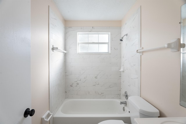 full bathroom with a textured ceiling, toilet, tiled shower / bath, and vanity