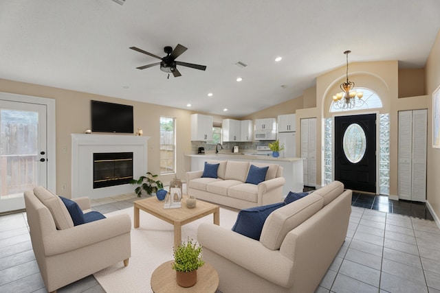 living area with a chandelier, a ceiling fan, light tile patterned floors, recessed lighting, and vaulted ceiling