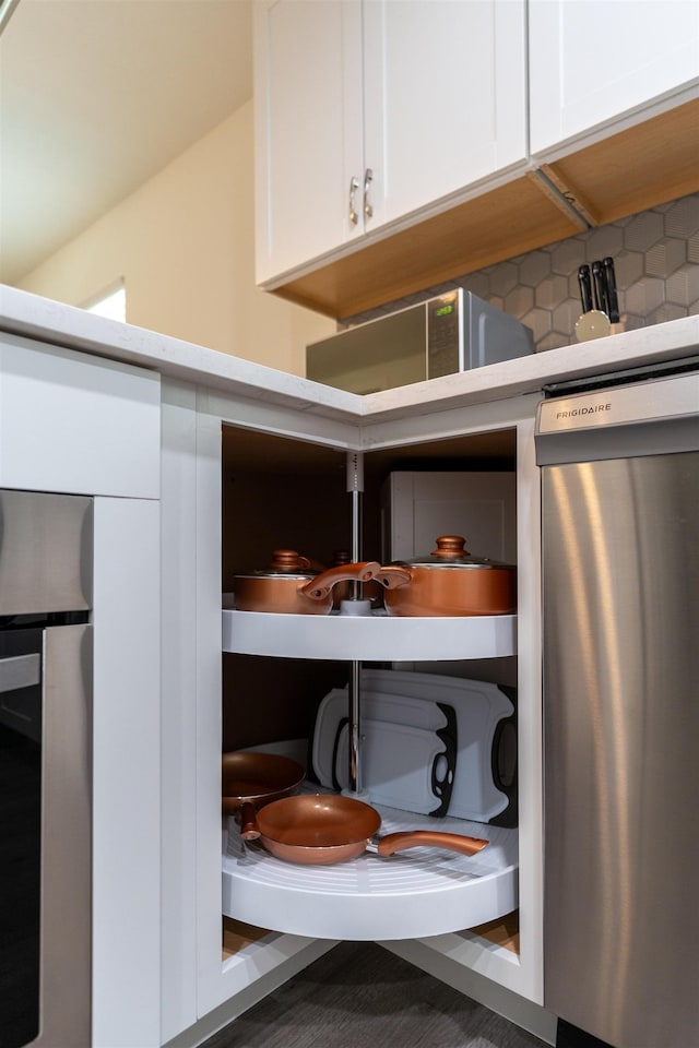 19 Phillips St, Saint Augustine, FL 32084 - room details featuring backsplash, stainless steel dishwasher, light countertops, and white cabinetry