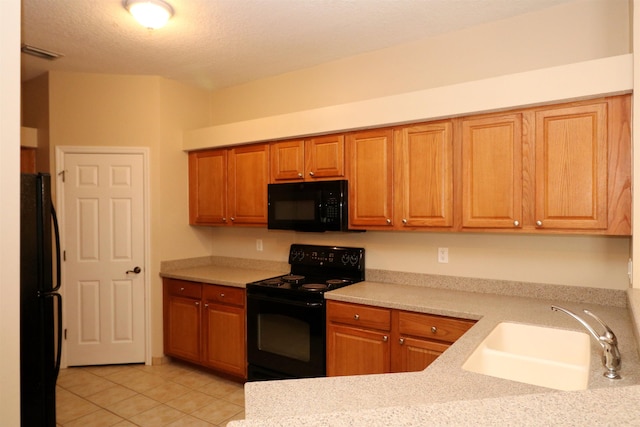 kitchen with a textured ceiling, light tile patterned floors, sink, and black appliances