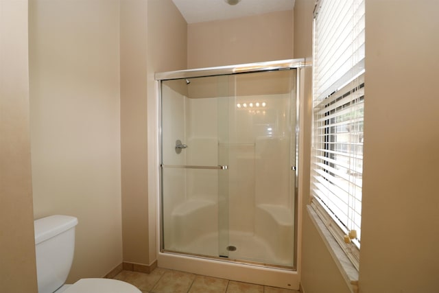 bathroom featuring toilet, tile patterned flooring, and an enclosed shower