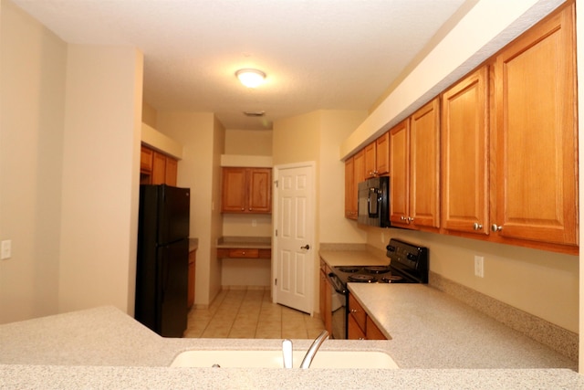 kitchen with light tile patterned floors, sink, and black appliances