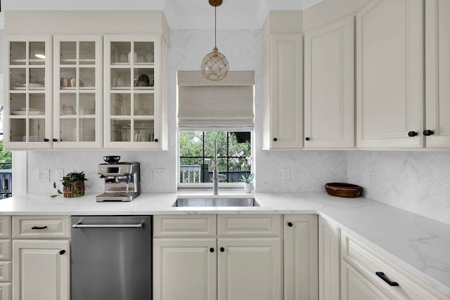 kitchen with tasteful backsplash, glass insert cabinets, stainless steel dishwasher, white cabinetry, and a sink