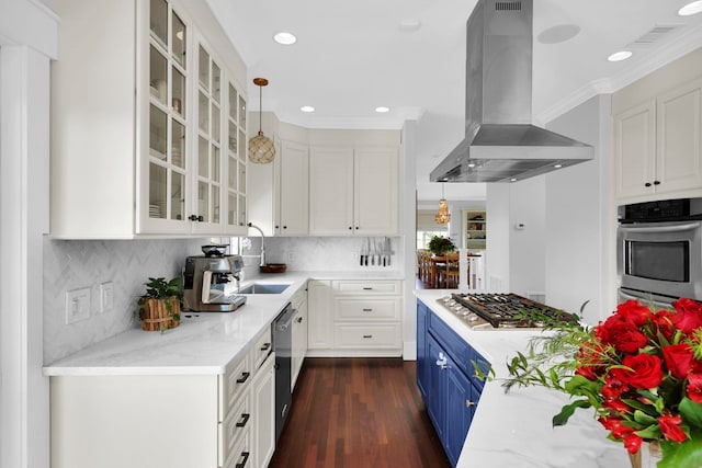 kitchen with stainless steel appliances, white cabinetry, crown molding, blue cabinets, and island range hood