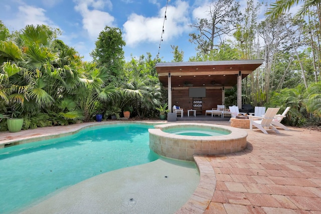 view of swimming pool with a patio, a ceiling fan, and a pool with connected hot tub