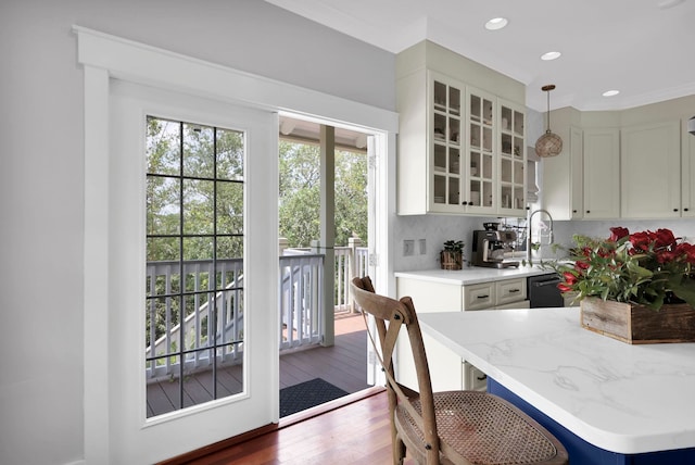 kitchen featuring white cabinets, light stone countertops, glass insert cabinets, and wood finished floors