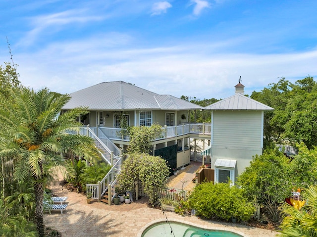 back of property with stairway and metal roof