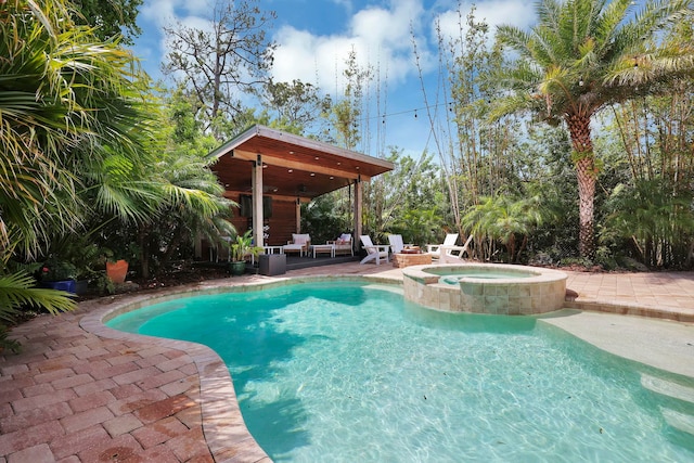 view of pool with a pool with connected hot tub and a patio