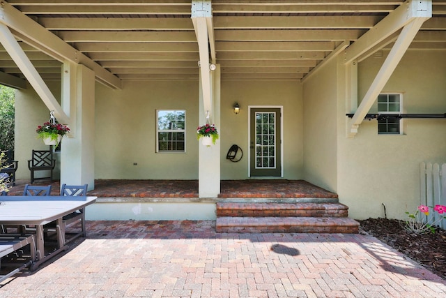 doorway to property with a patio area and stucco siding